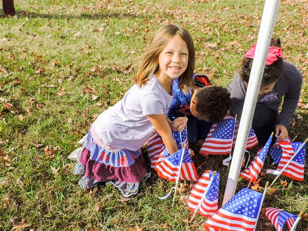 Students holding up homemade signs for a Veterans Day celebration.